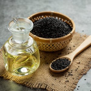Sesame oil and raw black sesame seeds on dark background Gingili oil